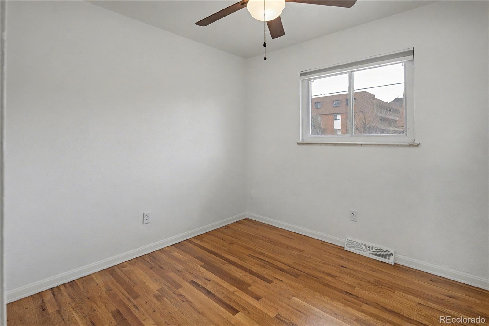 9142 Oberon Road Arvada, CO 80004 - Photo 11 of 35 an empty room with a window and wooden floor