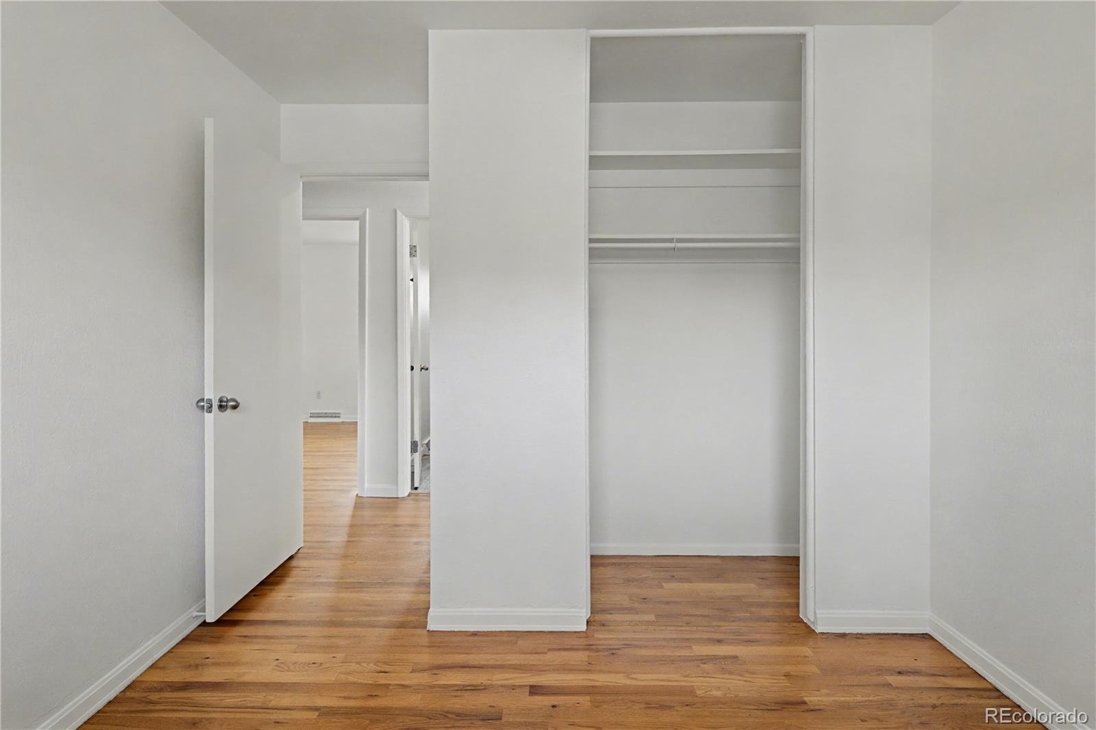 9142 Oberon Road Arvada, CO 80004 - Photo 12 of 35 a view of an empty room with closet and wooden floor