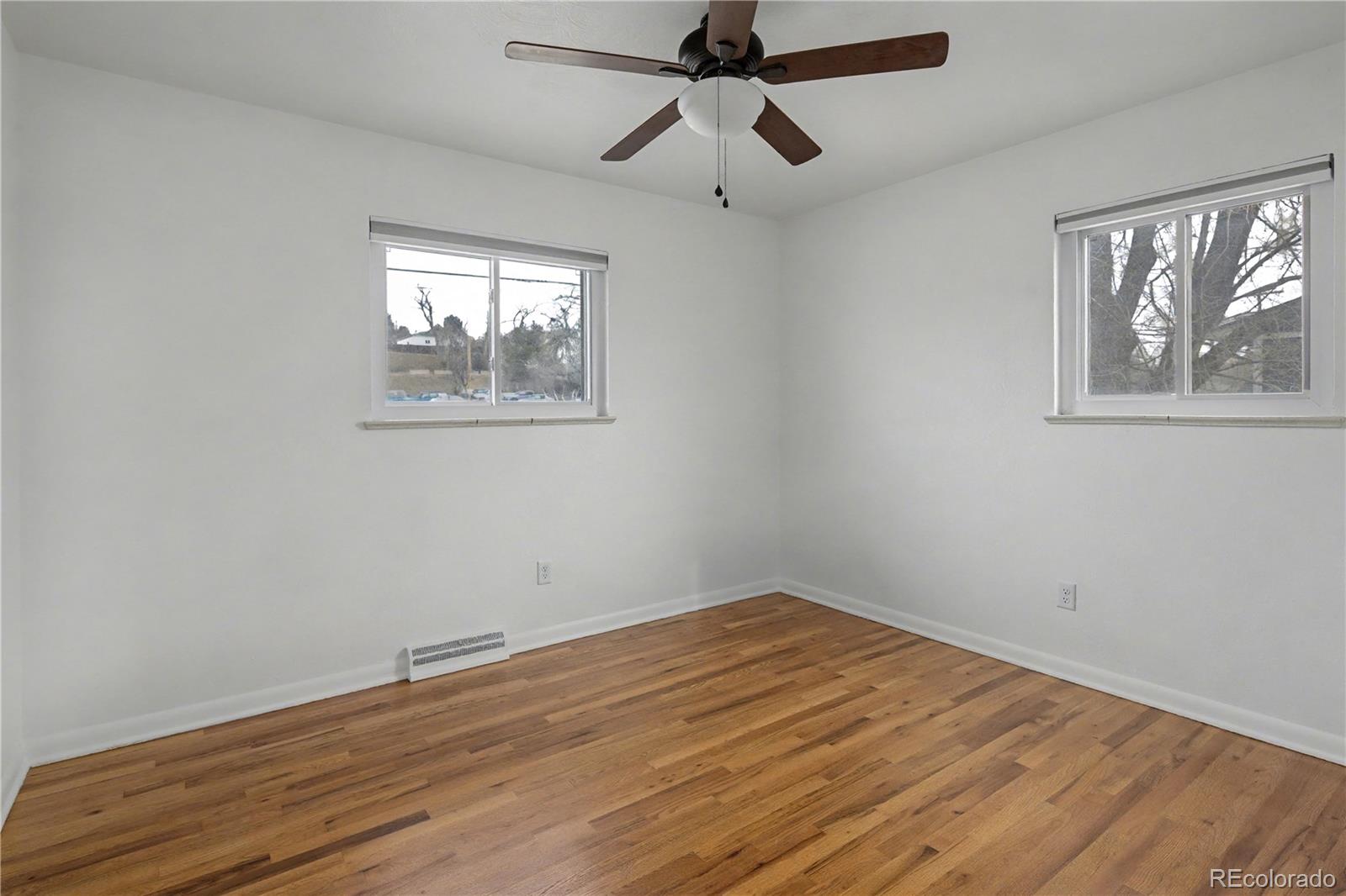 9142 Oberon Road Arvada, CO 80004 - Photo 14 of 35 a view of empty room with wooden floor and fan