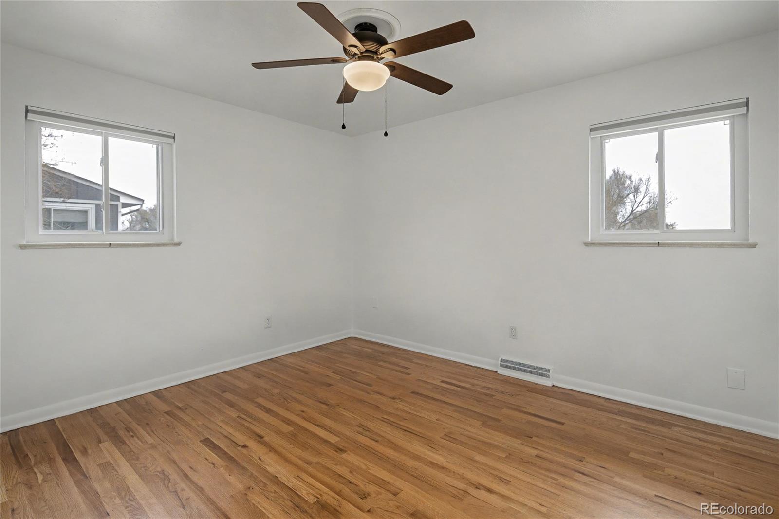 9142 Oberon Road Arvada, CO 80004 - Photo 16 of 35 wooden floor in an empty room with a window