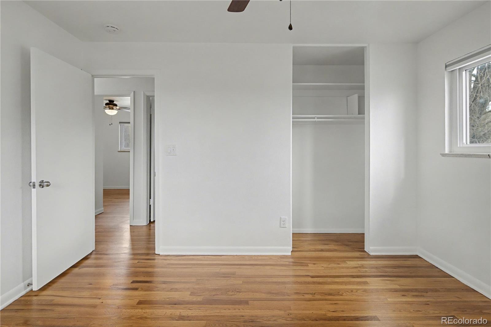 9142 Oberon Road Arvada, CO 80004 - Photo 17 of 35 a view of an empty room with closet and wooden floor