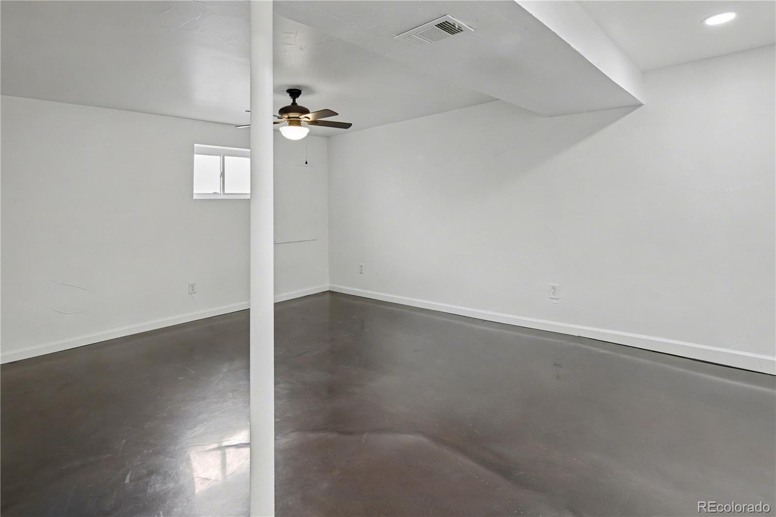 9142 Oberon Road Arvada, CO 80004 - Photo 23 of 35 an empty room with wooden floor fan and window