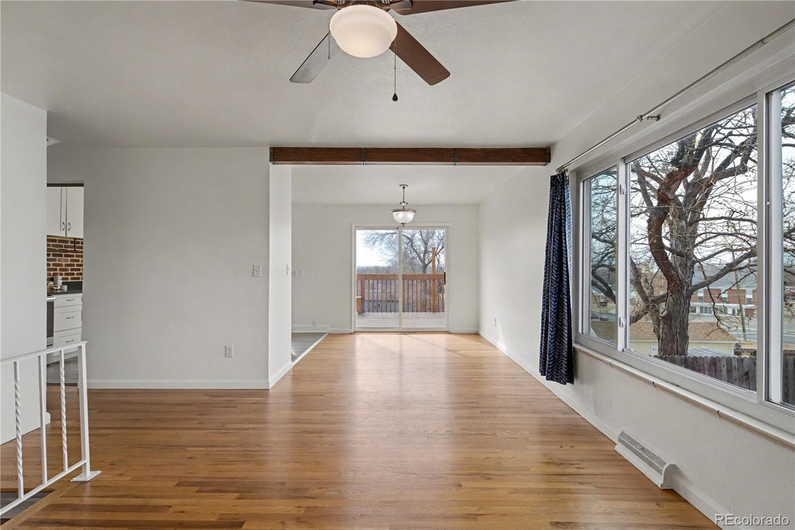 9142 Oberon Road Arvada, CO 80004 - Photo 5 of 35 a view of an empty room with wooden floor and a window