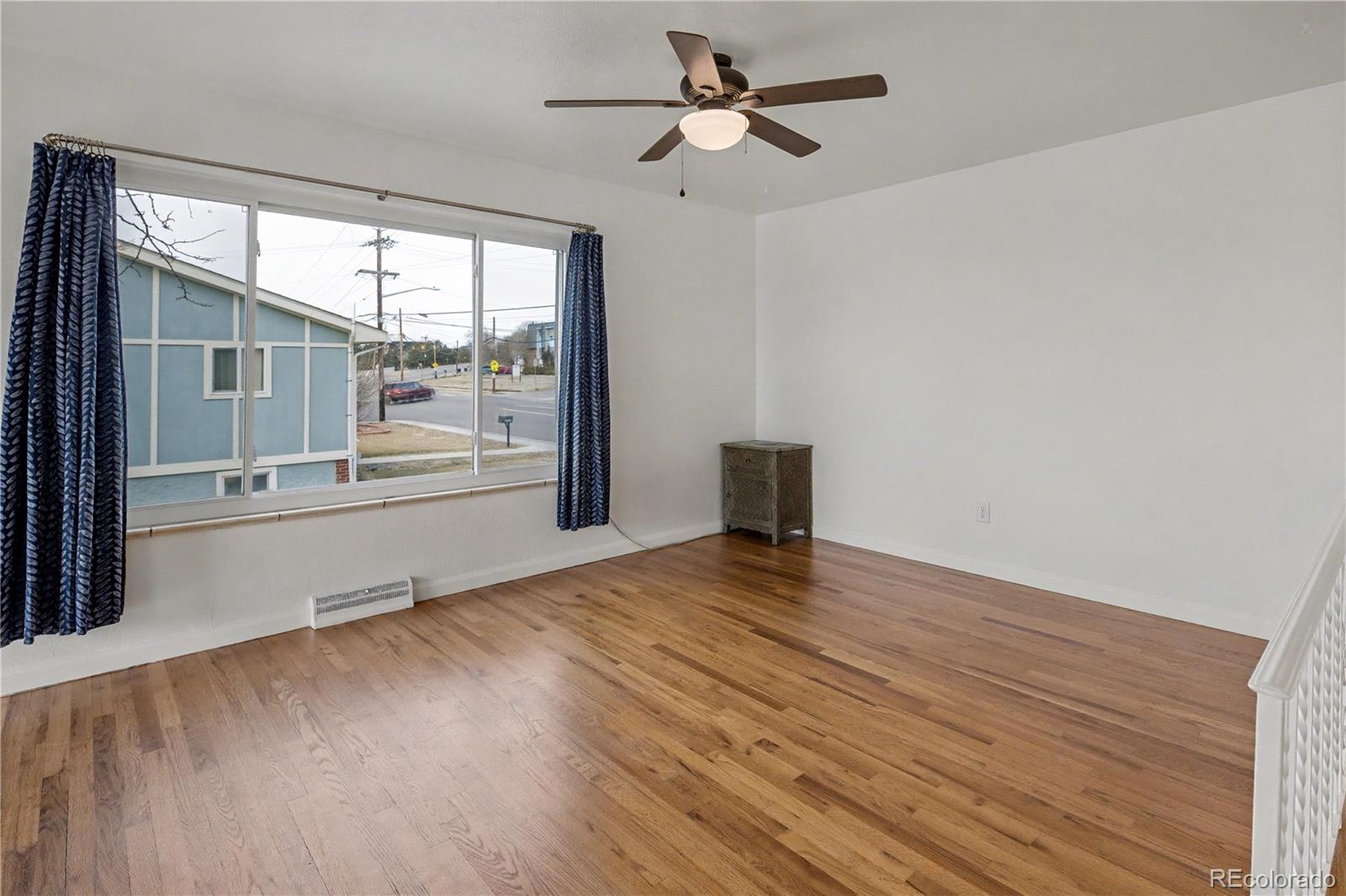 9142 Oberon Road Arvada, CO 80004 - Photo 8 of 35 a view of an empty room with a window and wooden floor
