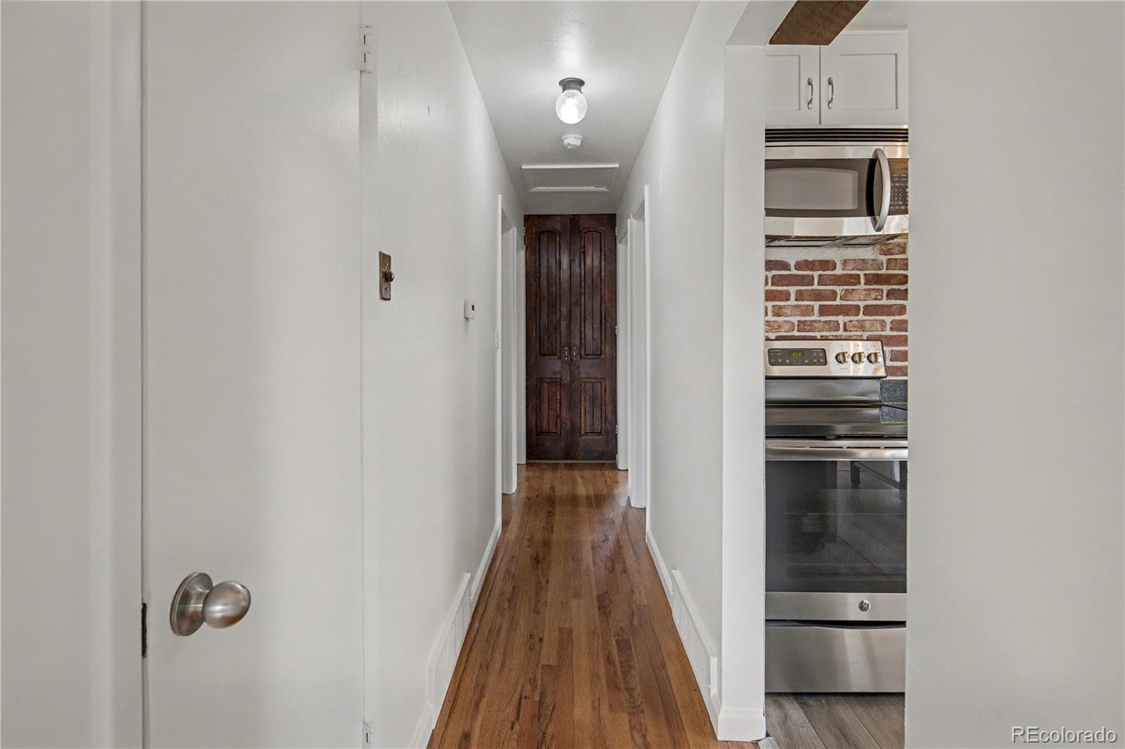 9142 Oberon Road Arvada, CO 80004 - Photo 9 of 35 a view of a hallway with wooden floor and entryway
