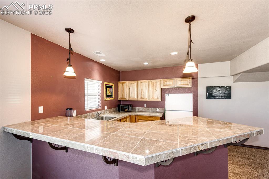 4685 County Road 106 Elbert, CO 80106 - Photo 27 of 43 a large kitchen with kitchen island a sink stainless steel appliances and a counter top