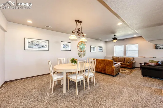 a living room with furniture a ceiling fan and a rug