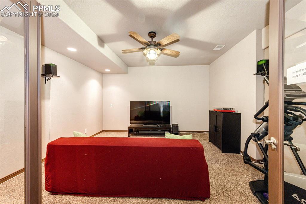 4685 County Road 106 Elbert, CO 80106 - Photo 35 of 43 a bedroom with a bed a flat screen tv and a chandelier