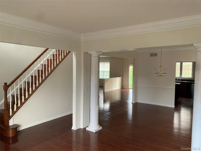 a view of a hallway with wooden floor windows and stairs