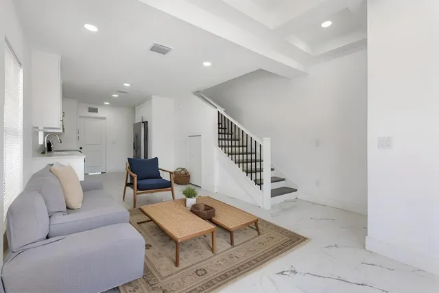 a living room with furniture and stairs