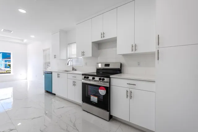 a kitchen with stainless steel appliances granite countertop a refrigerator stove and microwave