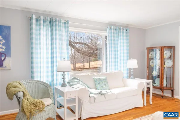 a living room with furniture and baby crib