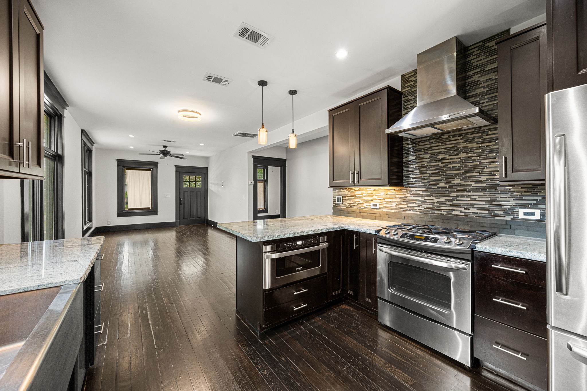 1115 Adele Street Houston, TX 77009 - Photo 3 of 19 Open-concept living and kitchen area with hardwood flooring and seamless flow for entertaining.