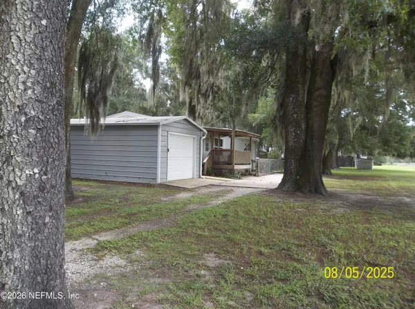 a view of a house with backyard and trees