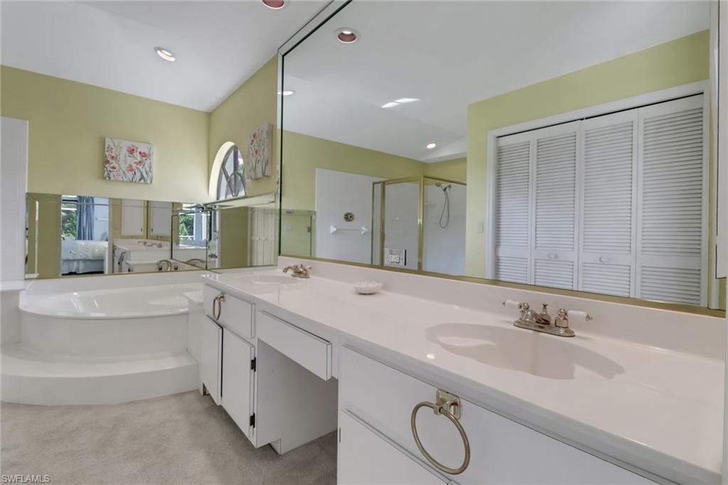 4961 Berkeley Drive Naples, FL 34112 - Photo 18 of 29 a spacious bathroom with a granite countertop sink and a mirror