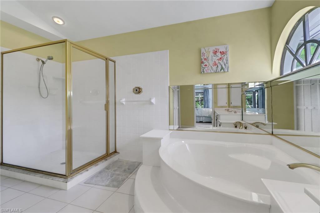 4961 Berkeley Drive Naples, FL 34112 - Photo 19 of 29 a bathroom with a tub a mirror and shower