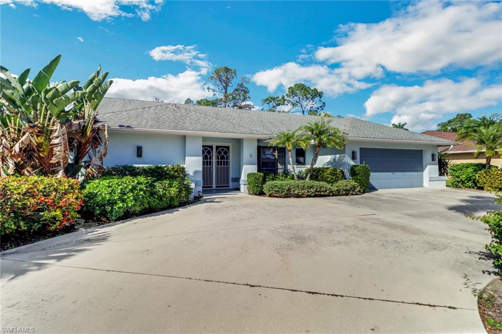 4961 Berkeley Drive Naples, FL 34112 - Photo 2 of 29 a front view of a house with a yard