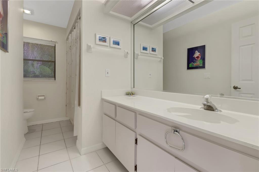4961 Berkeley Drive Naples, FL 34112 - Photo 24 of 29 a bathroom with a sink and a mirror