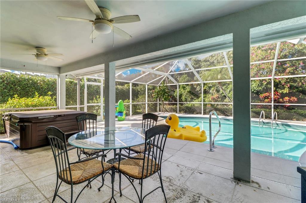 4961 Berkeley Drive Naples, FL 34112 - Photo 26 of 29 a dining room with furniture a rug and a floor to ceiling window