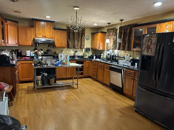 a kitchen with stainless steel appliances kitchen island granite countertop a refrigerator and a stove top oven