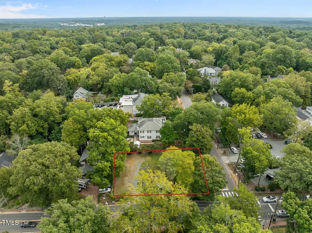 an aerial view of residential houses with outdoor space and trees