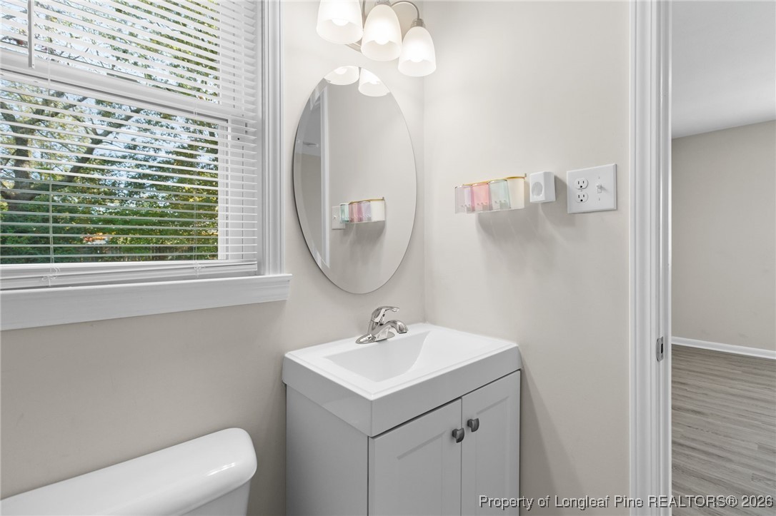 5414 Plateau Road Fayetteville, NC 28303 - Photo 17 of 27 a bathroom with a sink a mirror and a toilet