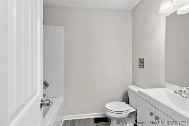 a bathroom with a granite countertop toilet and a sink