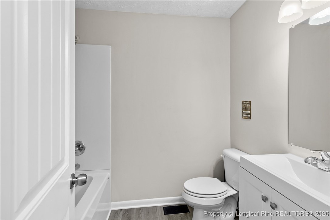 5414 Plateau Road Fayetteville, NC 28303 - Photo 20 of 27 a bathroom with a granite countertop toilet and a sink