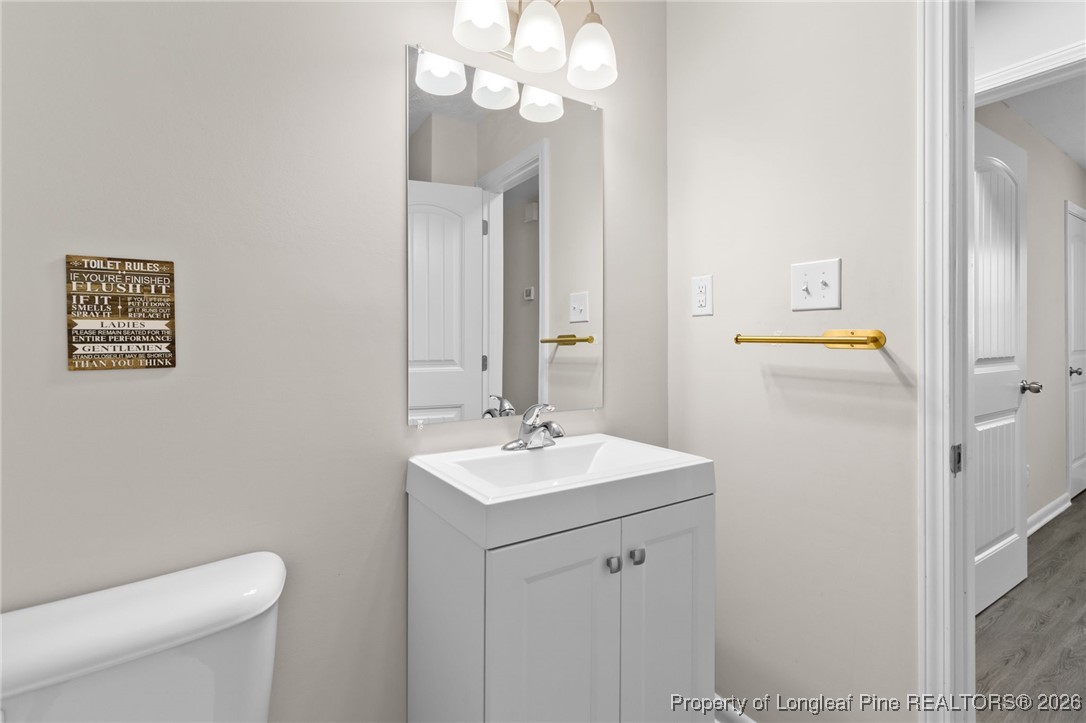 5414 Plateau Road Fayetteville, NC 28303 - Photo 21 of 27 a bathroom with a sink a toilet and a mirror