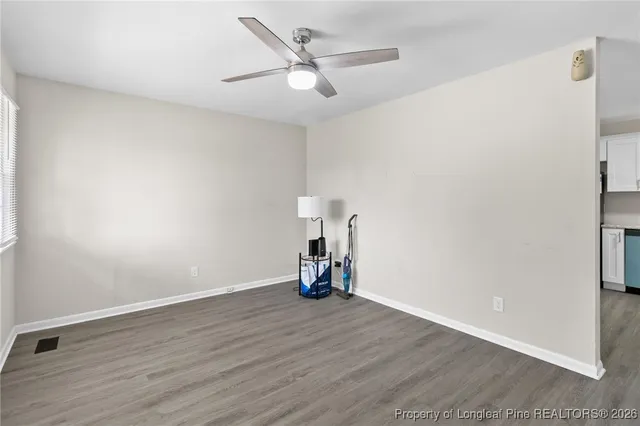 an empty room with wooden floor and a ceiling fan
