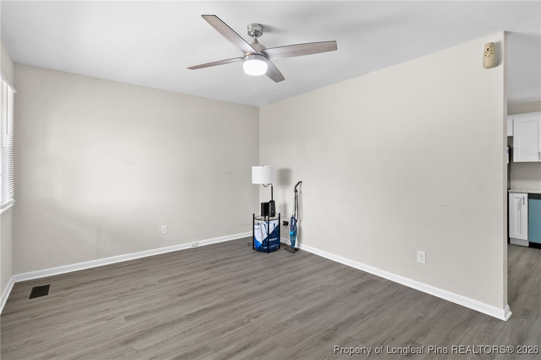 5414 Plateau Road Fayetteville, NC 28303 - Photo 6 of 27 an empty room with wooden floor and a ceiling fan