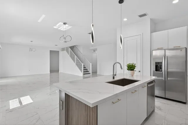 a view of an empty room with a floor to ceiling window and a kitchen