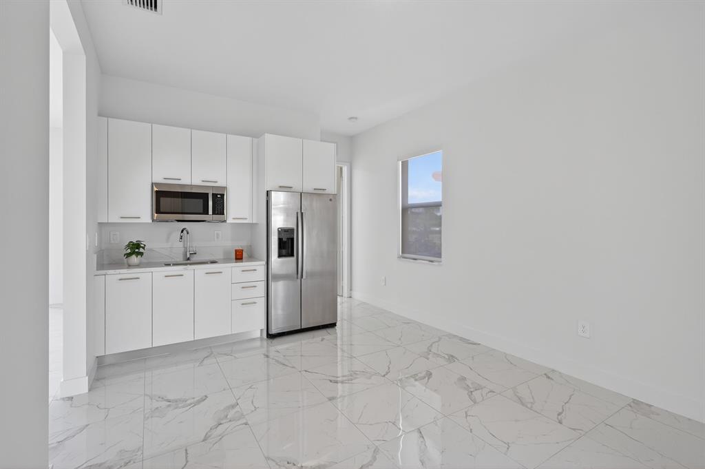 4421 Southwest 123rd Avenue Davie, FL 33330 - Photo 23 of 62 a kitchen with white cabinets and stainless steel appliances