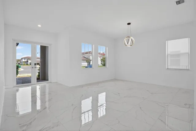 an empty room with windows and flowerpot