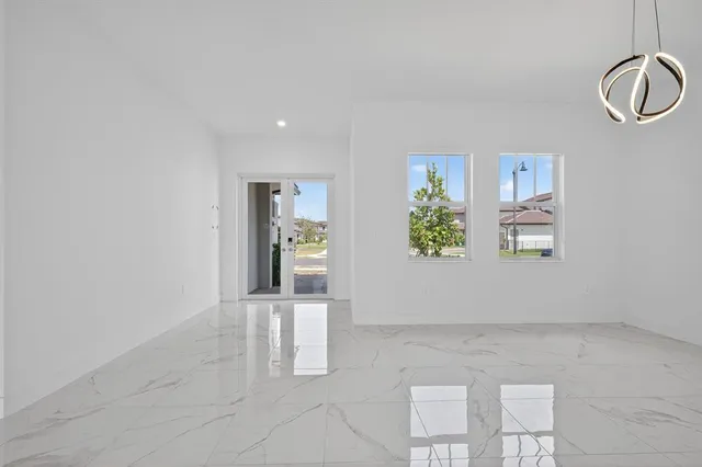 a kitchen with stainless steel appliances granite countertop a sink a stove a refrigerator and white cabinets