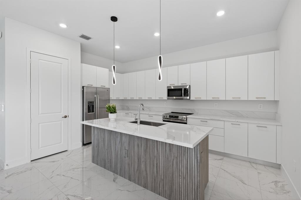 4421 Southwest 123rd Avenue Davie, FL 33330 - Photo 10 of 62 a kitchen with stainless steel appliances a stove a sink a refrigerator and white cabinets with wooden floor