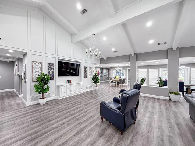 a living room with furniture flat screen tv and wooden floor