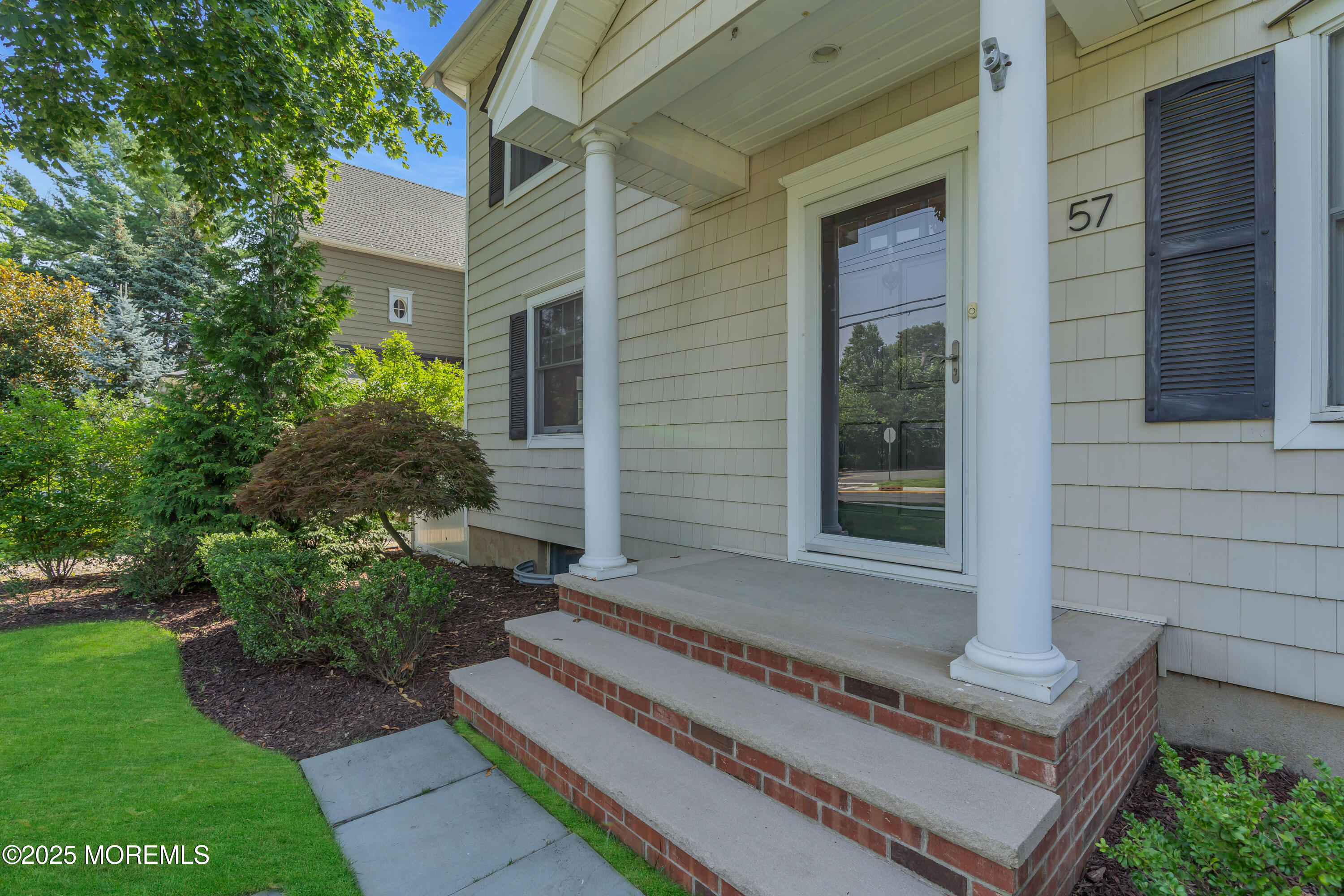 57 W River Road Rumson, NJ 07760 - Photo 31 of 44 a front view of a house with a garden