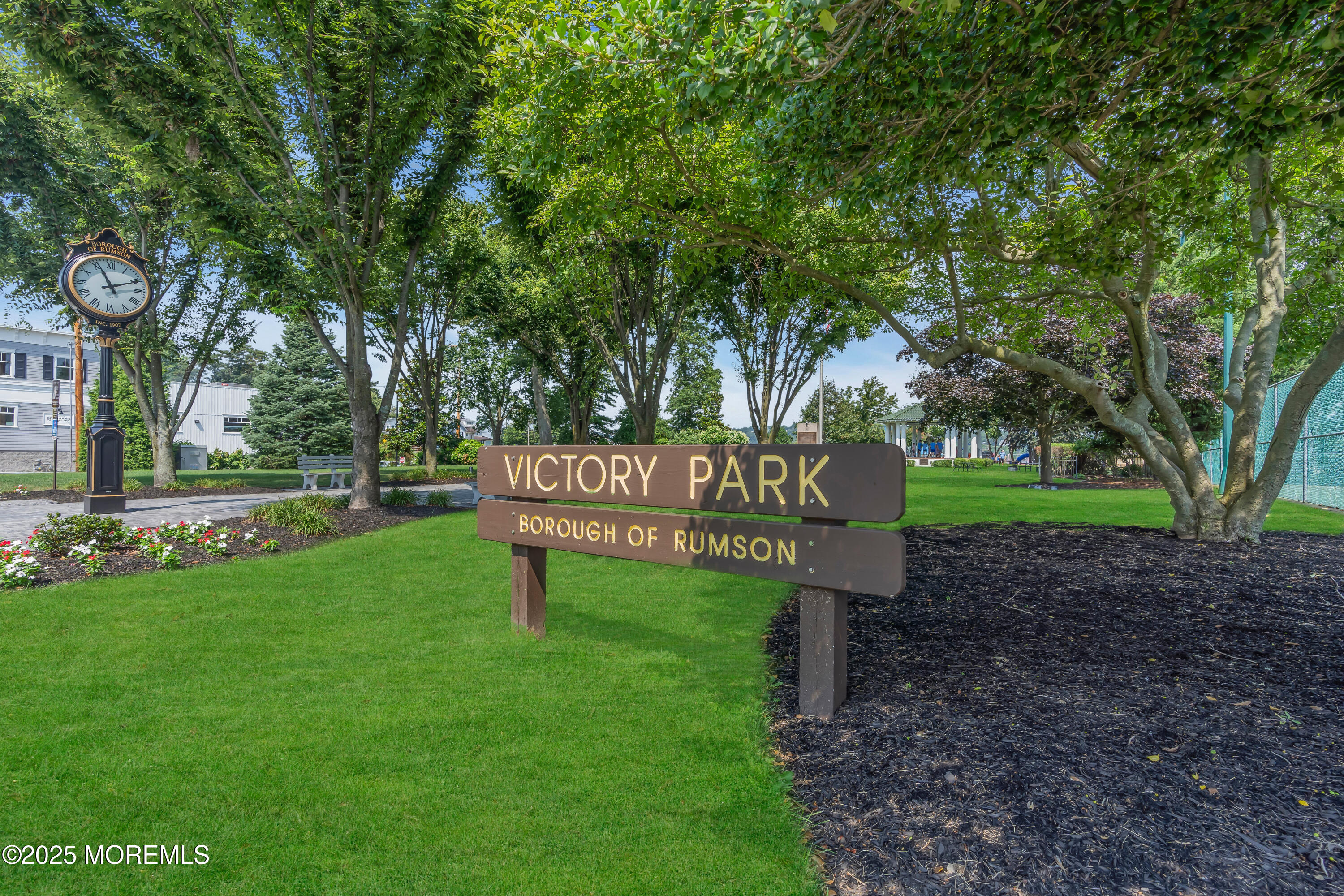 57 W River Road Rumson, NJ 07760 - Photo 40 of 44 a sign that is sitting in the grass near a tree