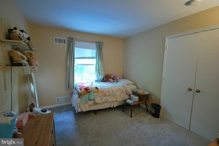 13628 Middlevale Lane Silver Spring, MD 20906 - Photo 16 of 25 a bedroom with a bed and a mirror