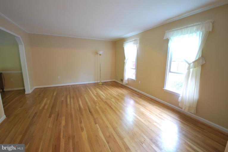 13628 Middlevale Lane Silver Spring, MD 20906 - Photo 19 of 25 a view of an empty room with wooden floor and a window