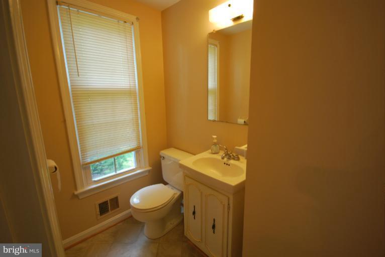 13628 Middlevale Lane Silver Spring, MD 20906 - Photo 23 of 25 a bathroom with a toilet a sink and a mirror