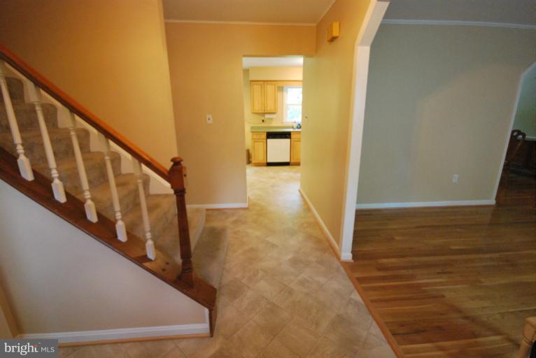 13628 Middlevale Lane Silver Spring, MD 20906 - Photo 25 of 25 a view of a hallway to an empty room with wooden floor and stairs