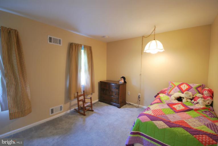 13628 Middlevale Lane Silver Spring, MD 20906 - Photo 8 of 25 a bedroom with a bed and a chandelier