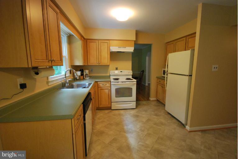 13628 Middlevale Lane Silver Spring, MD 20906 - Photo 9 of 25 a kitchen with stainless steel appliances white cabinets and a refrigerator
