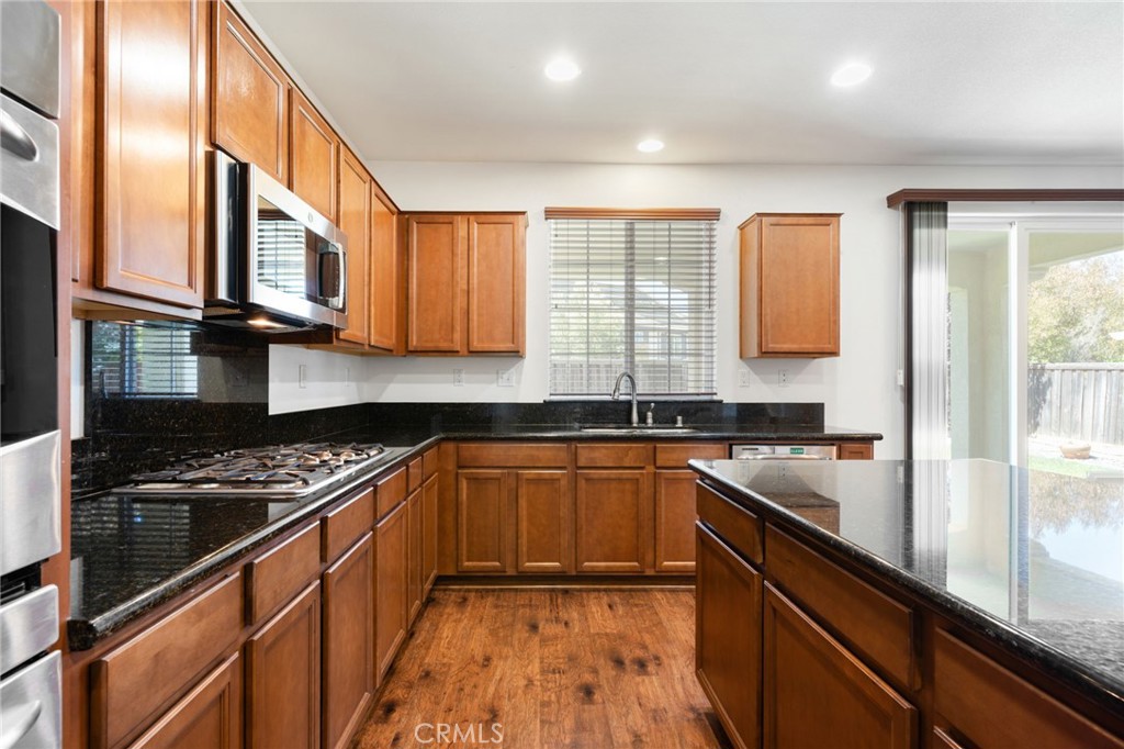 46545 Peach Tree Street Temecula, CA 92592 - Photo 11 of 48 a kitchen with stainless steel appliances granite countertop a stove a sink and a microwave