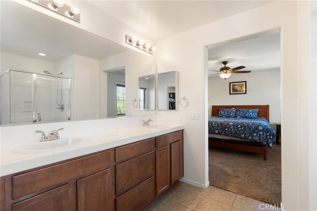 46545 Peach Tree Street Temecula, CA 92592 - Photo 30 of 48 a en suite bathroom with a double vanity sink and a mirror