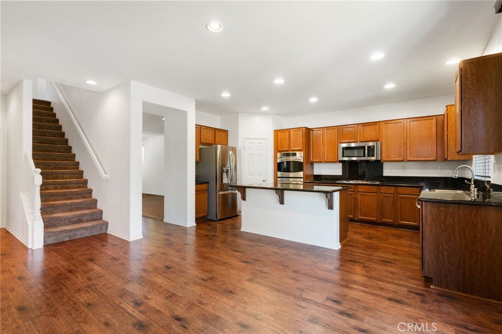 46545 Peach Tree Street Temecula, CA 92592 - Photo 9 of 48 a view of kitchen with microwave a stove and wooden floor