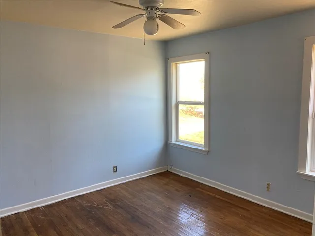 an empty room with a window and a fan