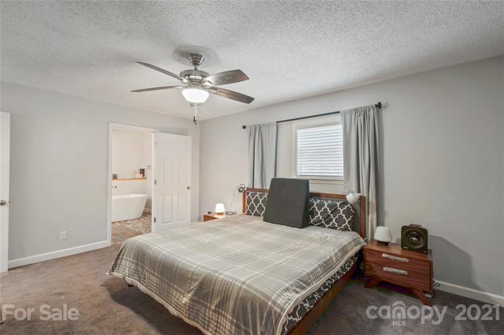 167 Mooreland Road, Unit 94 Mooresville, NC 28117 - Photo 13 of 34 a bedroom with a bed and a chandelier